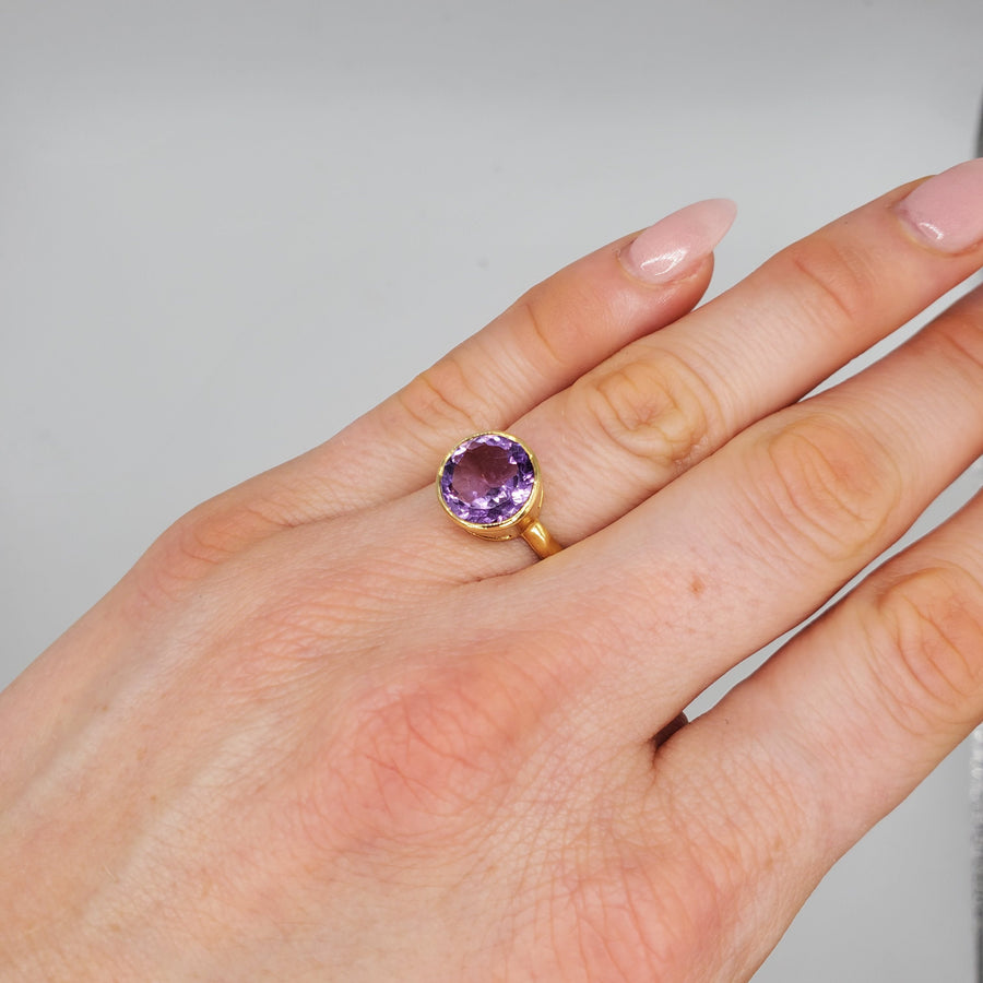 Vibrant round-cut Amethyst Center stone encased in 14k gold and a pounded band. The texture of the band brings in light to enhance the beauty of the stone
14 Kt Yellow Gold
Amethyst
Hand Crafted
available in every size
Round cut