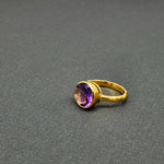Vibrant round-cut Amethyst Center stone encased in 14k gold and a pounded band. The texture of the band brings in light to enhance the beauty of the stone
14 Kt Yellow Gold
Amethyst
Hand Crafted
available in every size
Round cut
